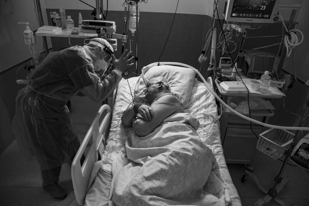 Liis Treimann – „Koroonapalat”. Vladimir oli pildistamise hetkeks Ida-Viru Keskhaiglas olnud kaheksa päeva. Arst juhendab teda parasjagu külje peal olema, see positsioon aitab paremini hingata. Foto on tehtud 2020. aasta talvel.
